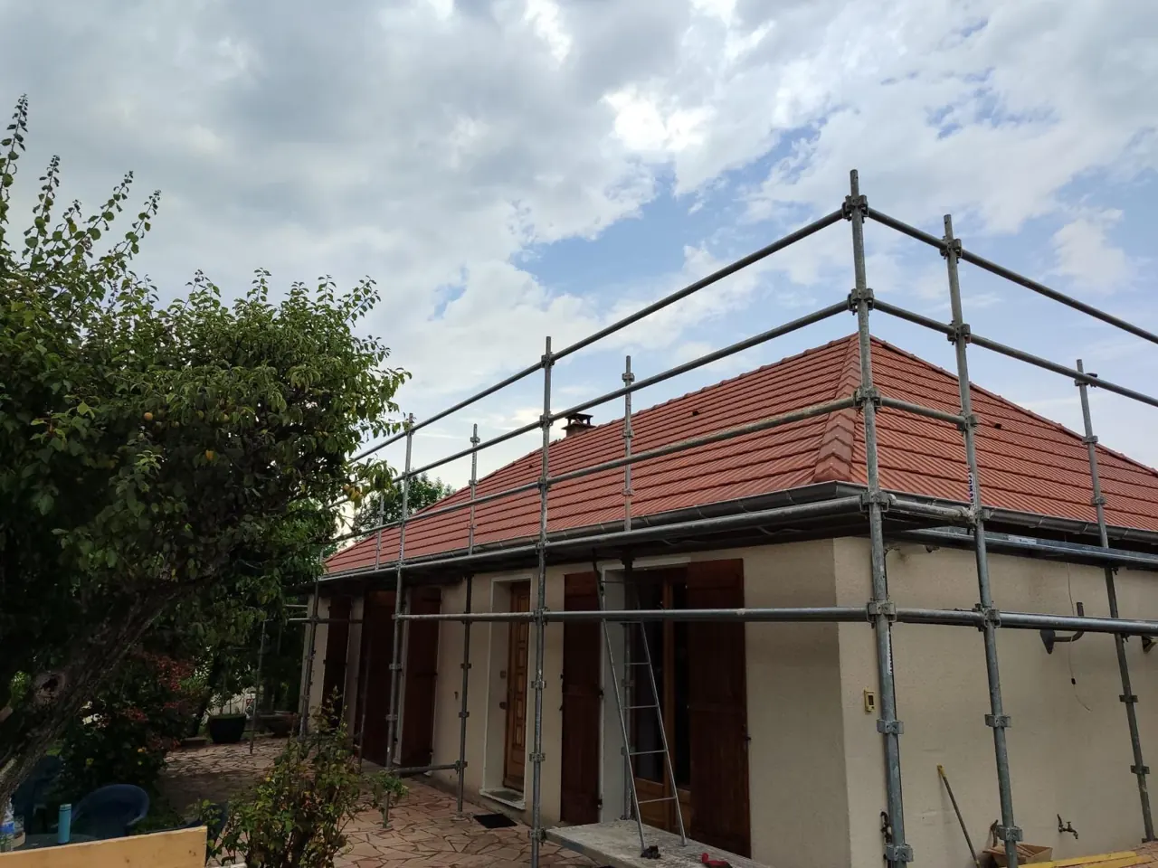 Échafaudage monté autour d'une maison pour la rénovation de sa toiture