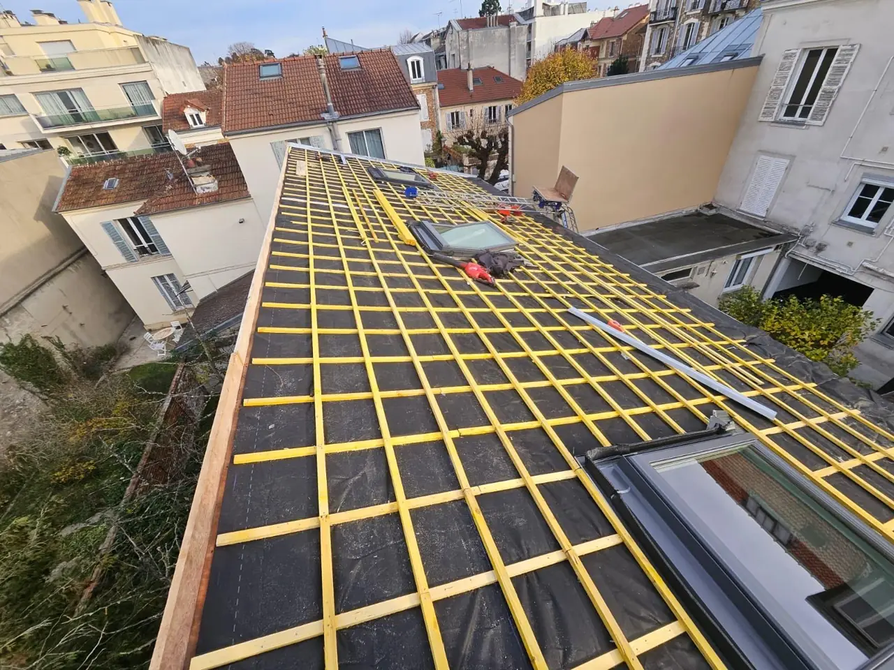 Écran sous-toiture et liteaux posés autour de deux fenêtres de toit