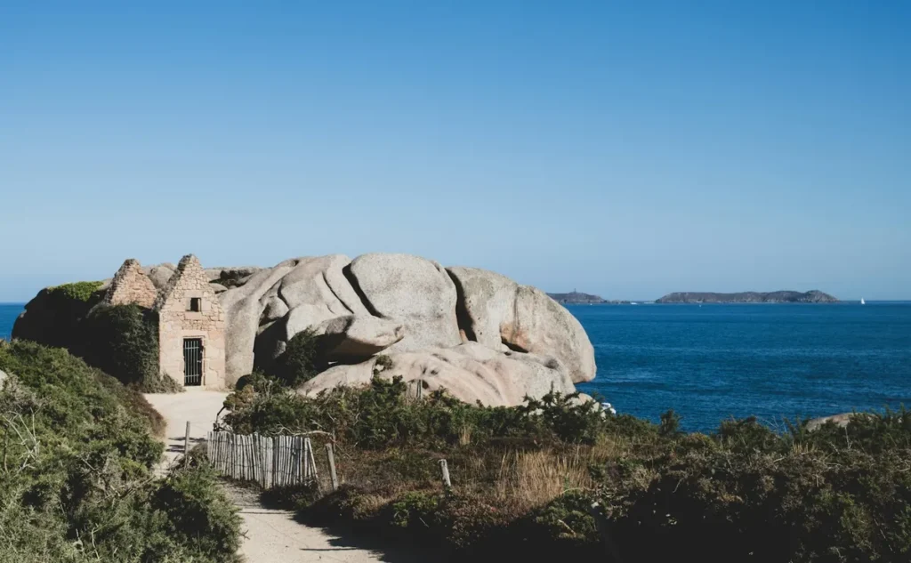 Maison en pierre entre des rochers de granit, au bord de la mer